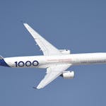 Airbus A350-1000 plane soaring in a clear sky, showcasing modern aerospace technology.