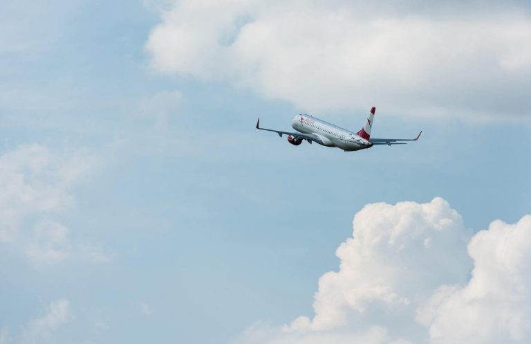 Passenger airplane against a clear blue sky with white clouds