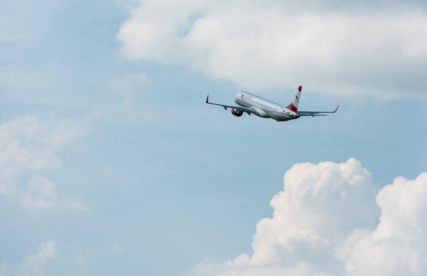 A passenger aeroplane against a clear blue sky with white clouds