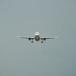 Passenger airplane approaching for landing against a clear blue sky.